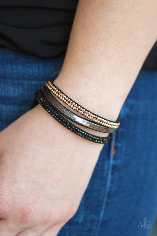 A brown suede band is spliced into three strands featuring rows of glittery hematite rhinestones, flat brass chain, and faceted metallic rhinestones for a glamorous look. Features an adjustable snap closure.

Sold as one individual bracelet.