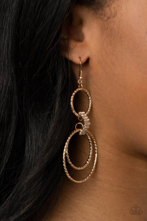 Featuring shimmery diamond-cuts, a trio of textured gold hoops swing from a white rhinestone encrusted gold fitting, creating a glamorously layered hoop. Earring attaches to a standard fishhook fitting.

Sold as one pair of earrings.