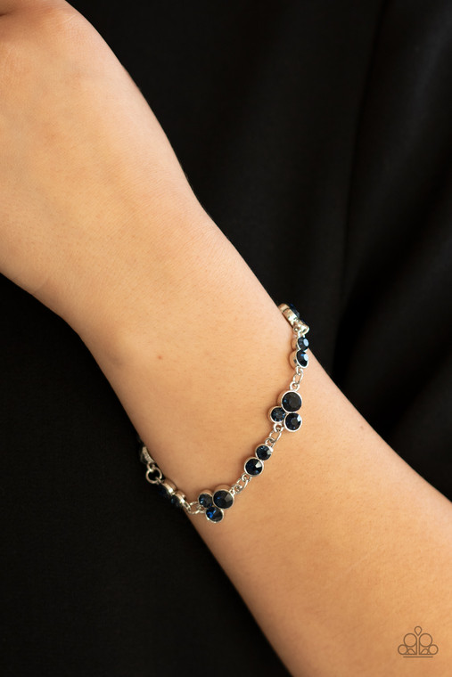 Encased in sleek silver frames, dainty pairs and trios of glittery blue rhinestones delicately link into a timeless display around the wrist. Features an adjustable clasp closure.

Sold as one individual bracelet.