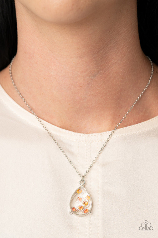 An illusion of dainty orange rhinestones collect inside a faceted white teardrop gem, creating a glittery pendant below the collar. Features an adjustable clasp closure.

Sold as one individual necklace. Includes one pair of matching earrings.