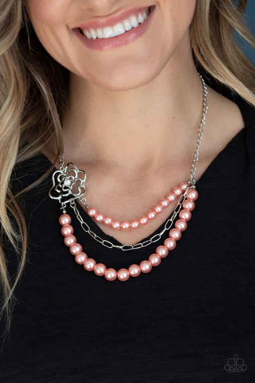 Dotted with a glassy white rhinestone center, an airy silver floral frame gives way to layers of coral pearls and a shiny row of silver chain below the collar for a whimsically refined look. Features an adjustable clasp closure.

Sold as one individual necklace. Includes one pair of matching earrings.