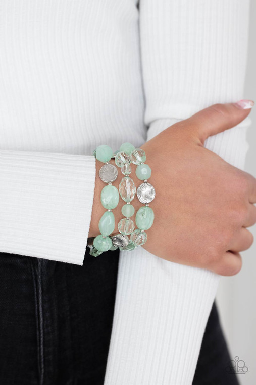 Glassy and opaque Green Ash crystal-like beads and textured silver accents are threaded along stretchy bands around the wrist, creating mystical layers.

Sold as one set of three bracelets.