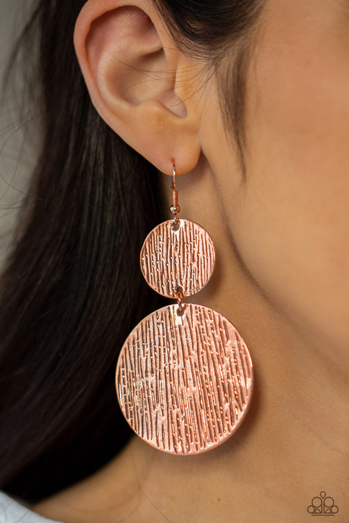 Embossed in tactile linear patterns, two mismatched copper discs link into a glistening lure. Earring attaches to a standard fishhook fitting.

Sold as one pair of earrings.