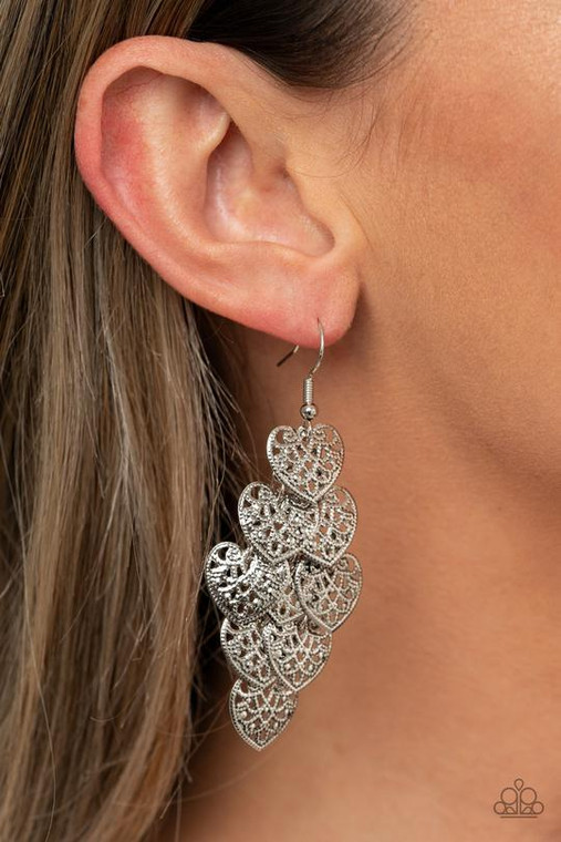 Featuring studded filigree filled centers, rustic silver heart frames cascade from the ear as they link into a flawless overlapping lure. Earring attaches to a standard fishhook fitting.

Sold as one pair of earrings.
