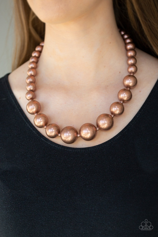 A collection of bold copper beads are threaded along an invisible wire below the collar. The antiqued beads dramatically increase in size as they reach the center for an undeniable statement-making finish. Features an adjustable clasp closure.

Sold as one individual necklace. Includes one pair of matching earrings.