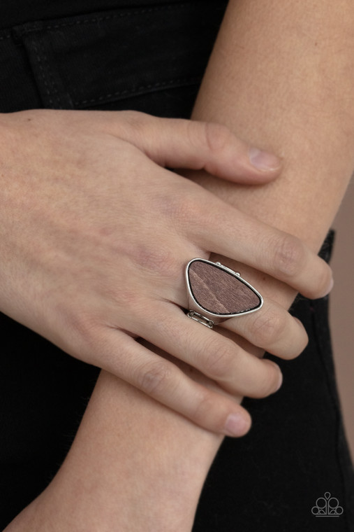 An asymmetrical piece of rustic wood is nestled inside a sleek silver frame that thickens into a shimmery band around the finger, creating a refined centerpiece. Features a stretchy band for a flexible fit.

Sold as one individual ring.