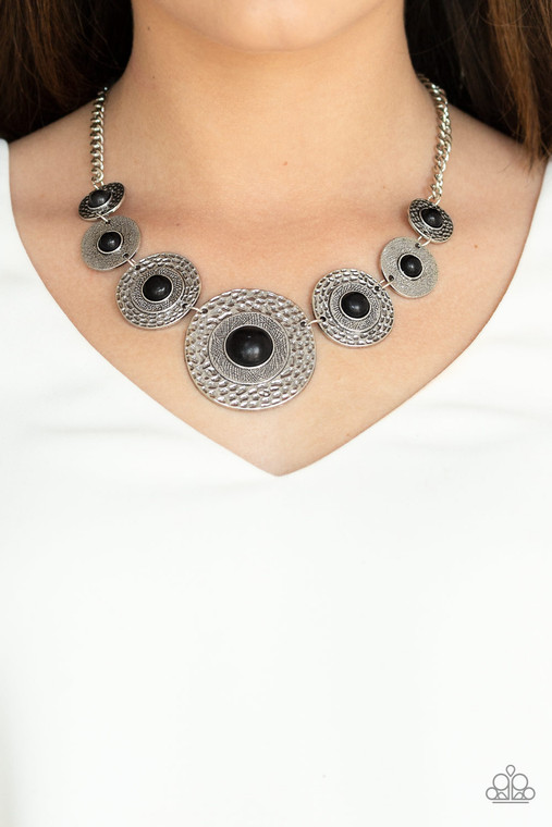 Dotted with smooth black stone centers, mismatched hammered silver frames gradually increase in size as they link below the collar for a fierce look. Features an adjustable clasp closure.

Sold as one individual necklace. Includes one pair of matching earrings.