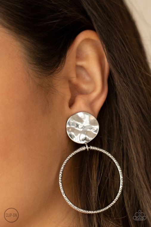 A textured silver hoop attaches to a hammered silver disc, creating an edgy hoop. Earring attaches to a standard clip-on fitting.

Sold as one pair of clip-on earrings.