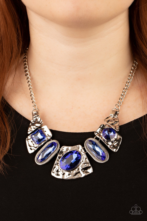 Mismatched French Blue gems adorn the front of hammered silver plates that abstractly connect below the collar, creating an out-of-this-world statement piece. Features an adjustable clasp closure.

Sold as one individual necklace. Includes one pair of matching earrings.