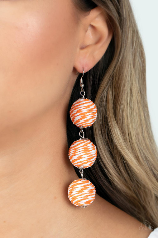 A woven collection of orange and white crepe-like strings ornately wraps around three hanging beads, reminiscent of decorative party lanterns. Earring attaches to a standard fishhook fitting.

Sold as one pair of earrings.