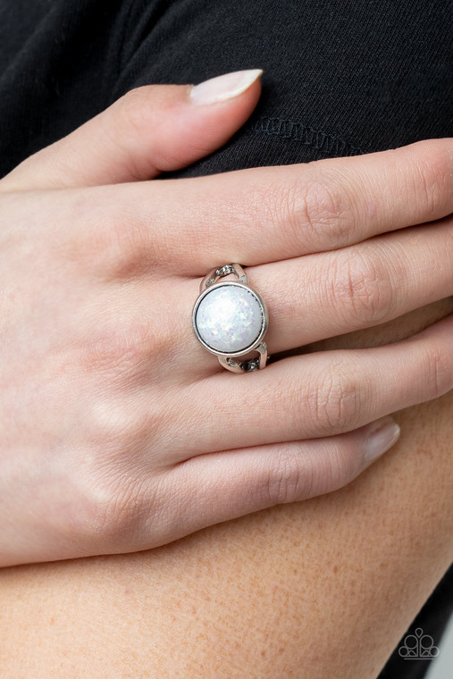 A white opalescent bead flecked with shimmering glitter is encased in a simple round silver frame creating a dazzling centerpiece atop the finger. Features a dainty stretchy band for a flexible fit.

Sold as one individual ring.