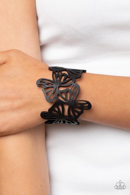 Featuring an airy stenciled pattern, black leather butterflies flutter across the wrist as they delicately connect into a rustic centerpiece. Features an adjustable snap closure.

Sold as one individual bracelet.