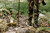 Hunter steadying rifle on XtraArm Solo Shooting Stick in open terrain