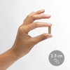 Hand holding a capsule beside a 2.5 cm size marker
