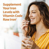 Woman taking a capsule with water, Vitamin Code RAW Iron graphic