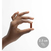 Hand holding a capsule with a 2.5 cm size marker