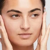 Model touching face with smooth primed skin
