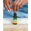 Hands squeezing a dropper on a Herb Pharm Reishi bottle