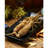 Whole tan Asian ginseng roots on a black plate botanical photo