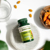 Turmeric bottle on a stone tray with tablets and turmeric root