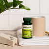 Stress Ease bottle on stone beside a cup, towel and two tablets