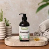 Kapha Massage Oil bottle on a stone tray beside towels and plants