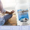 Person in yoga pose on a beach with NanoGluco Control bottle