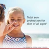 Child touching sunscreen on her nose with total sun protection for all ages text