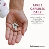 Three FertilAid capsules in an open hand with take three capsules daily text