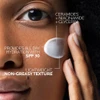 Woman with a dab of moisturizer near her eye, ingredient callouts