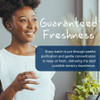 Woman taking a softgel with water, Wiley's Finest guaranteed freshness graphic