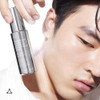Man holding the Tranexamic & Arbutin serum bottle near his face
