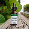 Cumanda dropper bottle on wood outdoors with green foliage