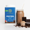Warrior Blend tub beside a chocolate shake and cacao