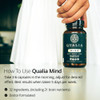 Hand lifting the bottle with how to use Qualia Mind text