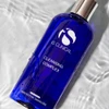 iS Clinical Cleansing Complex bottle lying in rippling water