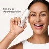 Smiling woman holding the bottle with for dry or dehydrated skin text
