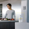 Woman preparing food in a kitchen with the bottle on the counter