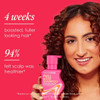 Woman holding Full Boost Shampoo 4-week fuller hair healthier scalp graphic