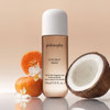 Coconut Rush body and hair fragrance mist with a halved coconut and orange flowers