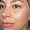 Woman cheek and eye with Champagne Skin Glow Stick highlight