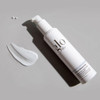 Oil Free Moisturizer bottle lying beside a cream swatch