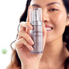 Smiling model holding epionce Intense Defense Serum bottle