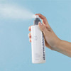 Hand spraying Dermalogica Multi-Active Toner mist against blue sky