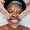 Smiling model receiving facial with Dermalogica Daily Microfoliant foam
