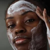 Model massaging Dermalogica Daily Microfoliant foam onto face