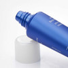 Open hand cream tube lying beside its white cap