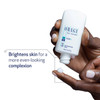 Hand dispensing Obagi Nu-Derm Clear Fx onto fingertip with brightening text
