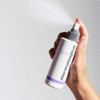 Hand spraying Dermalogica UltraCalming Mist, fine mist visible