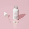 Phyto-Calm Aloe Drops bottle and dropper on a pink background